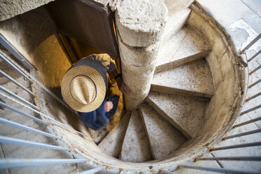 Italy, Sicily, Modica, man with hat on spiral staircase - MAMF00438