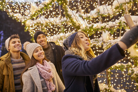 Fröhliche Freunde in Winterdekoration machen ein Selfie, lizenzfreies Stockfoto