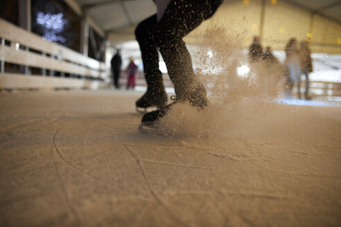 Beine eines Mannes beim Schlittschuhlaufen auf einer nächtlichen Eislaufbahn - ZEDF01900