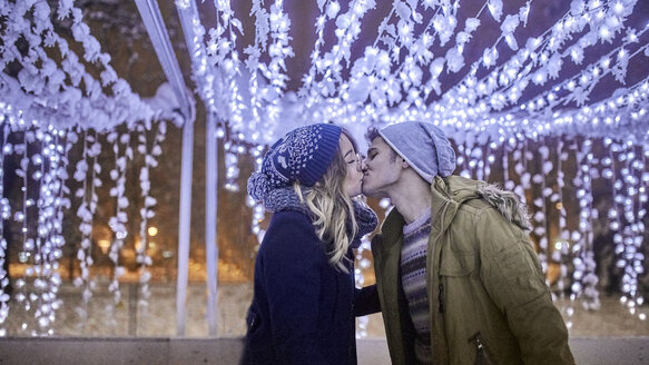 Junges Paar küsst sich in Winterdekoration - ZEDF01903