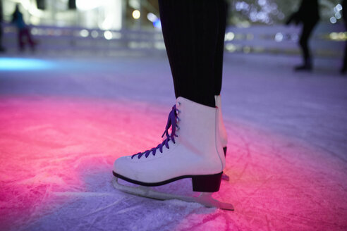 Leg of woman wearing ice skates standing on an ice rink - ZEDF01920