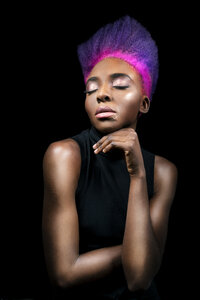 Porträt einer exzentrischen jungen Frau mit rosa und lila gefärbten Haaren vor einem schwarzen Hintergrund - DMOF00136