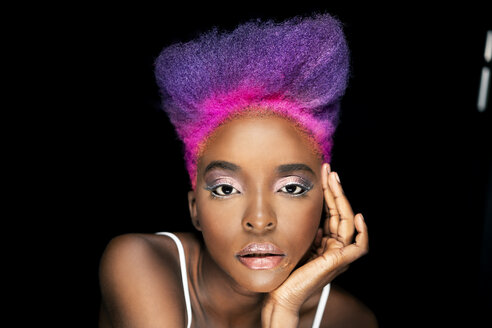 Porträt einer exzentrischen jungen Frau mit rosa und lila gefärbten Haaren vor einem schwarzen Hintergrund - DMOF00137