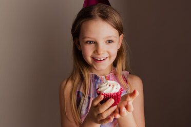 Porträt eines glücklichen kleinen Mädchens mit Tassenkuchen - NMS00289