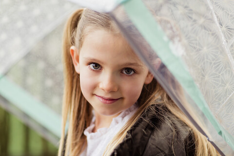 Porträt eines lächelnden Mädchens mit Regenschirm, lizenzfreies Stockfoto
