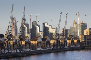 UK, London, Docklands, renovated residential buildings and harbor cranes, gondolas of the Emirates cable car - WIF03824