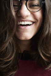 Porträt einer lachenden jungen Frau mit Brille - IGGF00812
