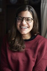 Porträt einer lachenden jungen Frau mit Brille - IGGF00814