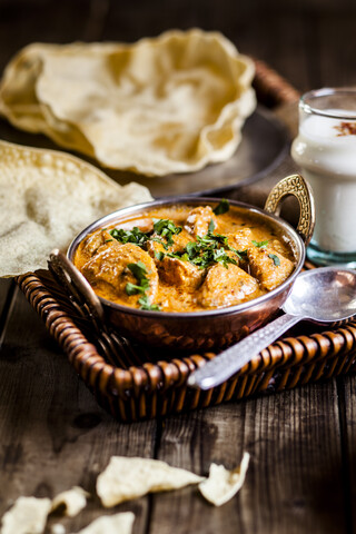 Indisches Butterhähnchen mit Papadam, Reis und Lassi, lizenzfreies Stockfoto