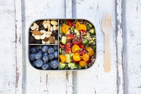 Lunchbox with quinoa salad with tomato and cucumber, blue berry and trail mix stock photo