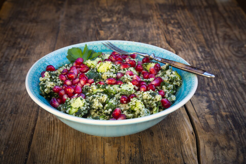 Schüssel Bulgur-Weizen-Salat mit Gurken, Kräutern, Granatapfelkernen und Petersilie, lizenzfreies Stockfoto