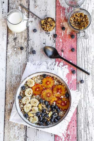 Müsli mit Banane, Blaubeeren, Blutorange, Kokosnussflocken und Milch, lizenzfreies Stockfoto