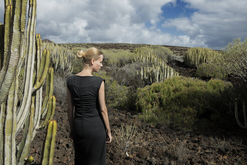 Spanien, Teneriffa, Malpais de Guimar, Frau in vulkanischer Landschaft mit Kakteen - PSTF00308