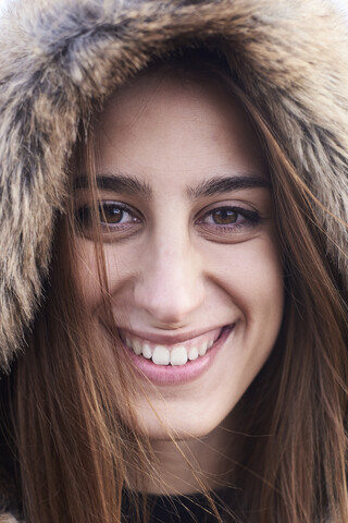 Portrait of happy young woman wearing fur hood stock photo