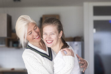 Portrait of laughing mother looking at adult daughter - SGF02293
