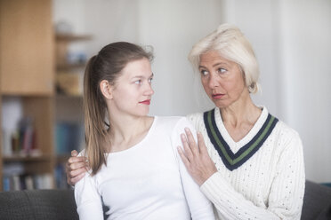 Sceptical young woman looking at her mother begging - SGF02306