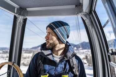 Germany, Bavaria, Brauneck, man in winter in gondola lift - DIGF05901