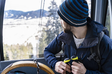 Germany, Bavaria, Brauneck, man in winter in gondola lift - DIGF05903