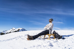 Germany, Bavaria, Brauneck, man in winter in the mountains having a break - DIGF05911