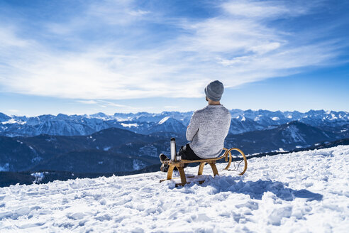 Germany, Bavaria, Brauneck, man in winter in the mountains having a break - DIGF05912
