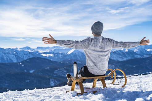Deutschland, Bayern, Brauneck, fröhlicher Mann im Winter in den Bergen, der eine Pause macht - DIGF05913