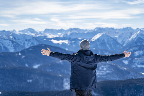 Deutschland, Bayern, Brauneck, Mann im Winter genießt die Aussicht in den Bergen, lizenzfreies Stockfoto
