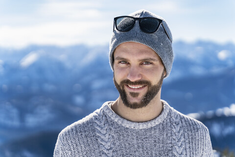 Deutschland, Bayern, Brauneck, Porträt eines lächelnden Mannes im Winter in den Bergen, lizenzfreies Stockfoto