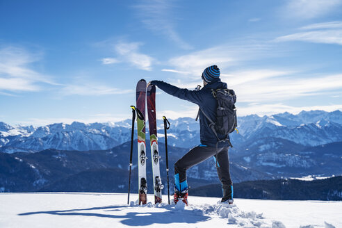 Deutschland, Bayern, Brauneck, Mann auf Skitour im Winter in den Bergen beim Pausieren - DIGF05955