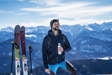 Deutschland, Bayern, Brauneck, Mann auf Skitour im Winter in den Bergen beim Pausieren - DIGF05959