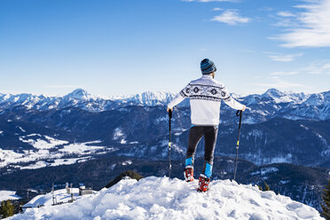 Deutschland, Bayern, Brauneck, Mann im Winter auf Berggipfel stehend - DIGF05970