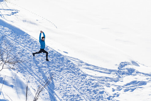 Deutschland, Bayern, sportlicher Mann beim Dehnen im Schnee im Winter - DIGF05997