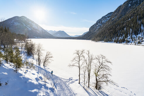 Deutschland, Bayern, Vogelperspektive eines Mannes, der in einer Winterlandschaft läuft - DIGF05998