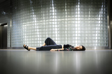 Sad young woman lying on the floor - DMOF00149