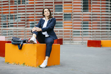 Businesswoman sitting outside office building in the city - JRFF02726