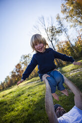 Porträt eines lachenden kleinen Jungen mit seinem Vater in der Natur - JLOF00316