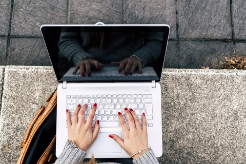 Nahaufnahme einer Frau, die einen Laptop im Freien benutzt, lizenzfreies Stockfoto