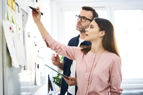 Zwei Kollegen diskutieren am Whiteboard im Büro - BSZF01001