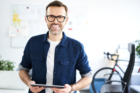 Porträt eines lächelnden Geschäftsmannes im Büro - BSZF01017