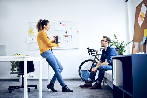 Zwei Kollegen mit Tablet treffen sich im Büro, lizenzfreies Stockfoto