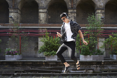 Young man listening music with headphones, hovering - IGGF00877