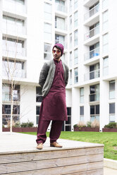 Volle Länge der modischen Mann in Sonnenbrille, lila Hut und lässige indische Kleidung gegen moderne Gebäude - IGGF00890