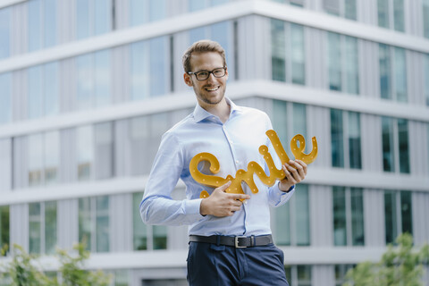 Young businessman holding smile sign stock photo