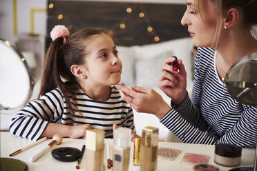 Mother and daughter applying make up together, using lipstick - ABIF01194