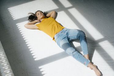 Frau liegt auf dem Boden und entspannt sich im Sonnenlicht - KNSF05627