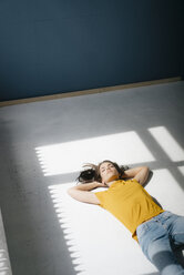 Frau liegt auf dem Boden und entspannt sich im Sonnenlicht - KNSF05630