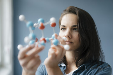 Female scientist studying molecule model, looking for solutions - KNSF05643