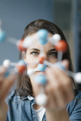 Female scientist studying molecule model, looking for solutions - KNSF05645