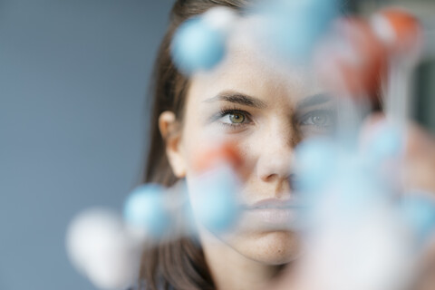 Female scientist studying molecule model, looking for solutions stock photo