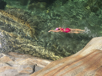 Switzerland, Ticino, Verzasca Valley, Val Versazca, woman swimming in refreshing Verzasca river - GWF05902