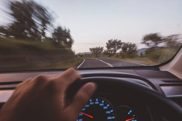 Abgeschnittene Hand eines Mannes, der ein Auto auf der Straße fährt - CAVF60699